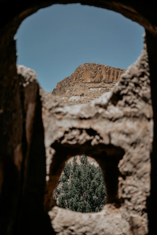 looking through a hole in a rock wall into the desert