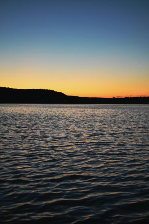 a view of a lake and mountains at dusk