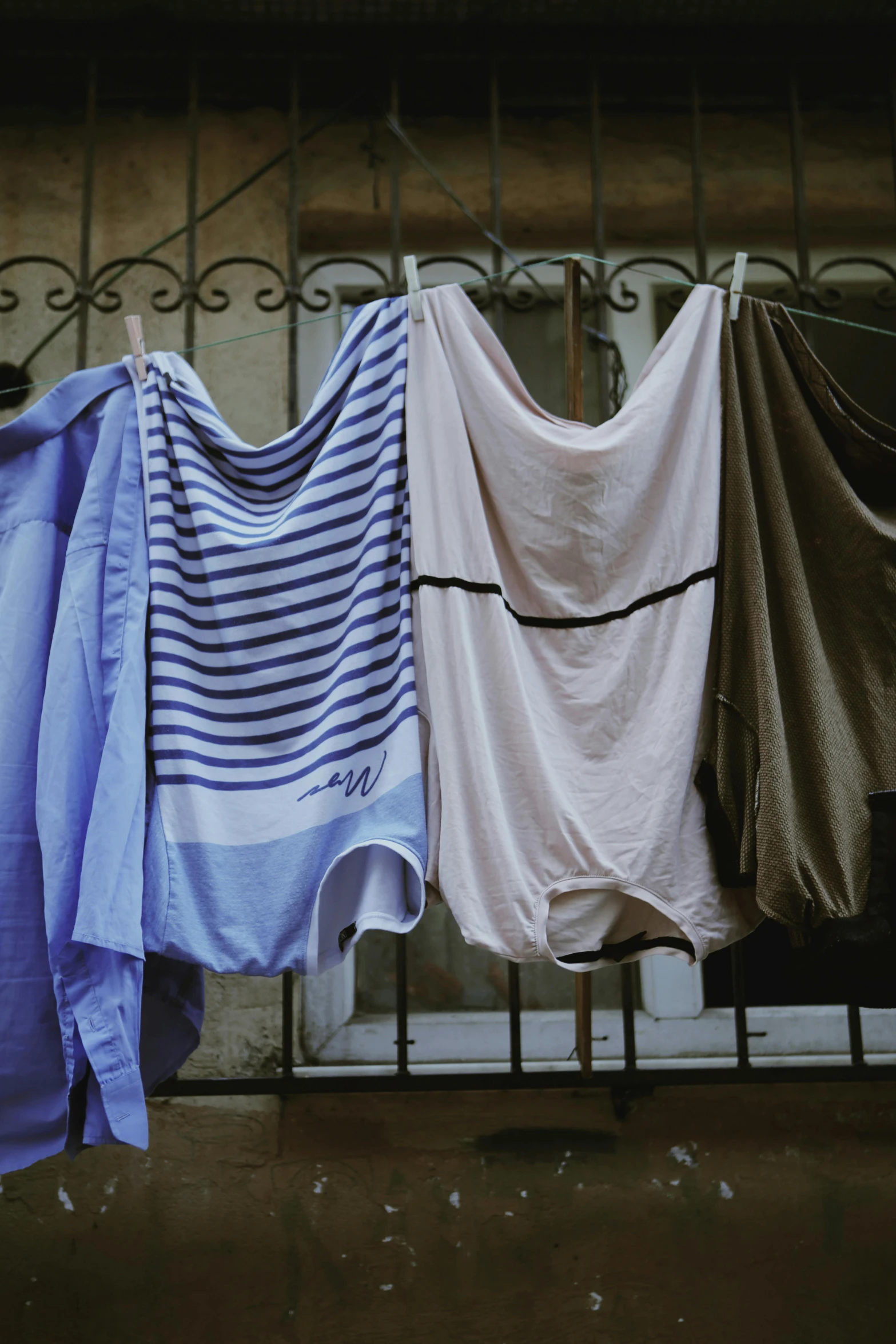 several small blue and tan shirts hanging on a line