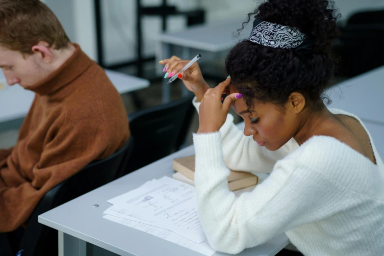 two students in a classroom one is reading a book