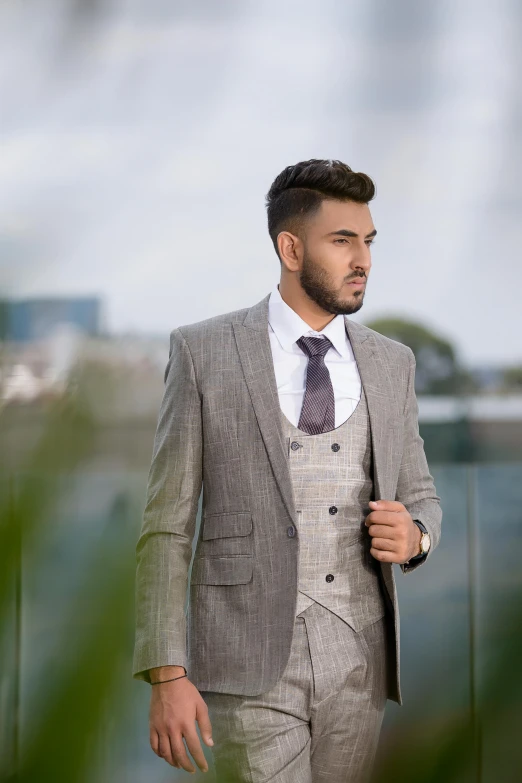 a man wearing a grey suit and a watch