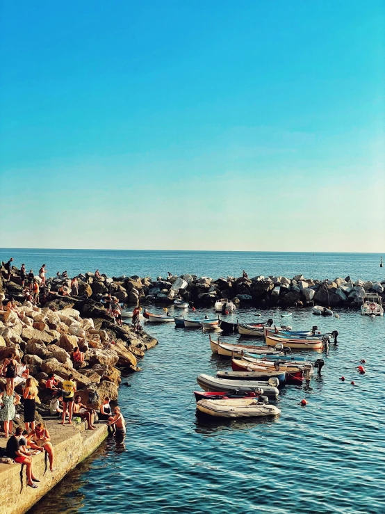 many people gather around the edge of the water