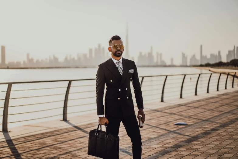 a man wearing business attire, holding a briefcase and posing for the camera