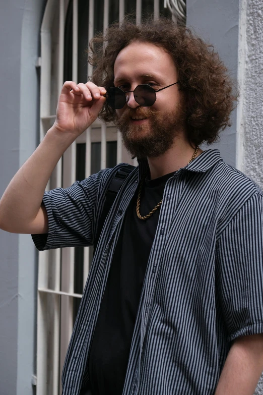 a man with a long beard is posing by a building