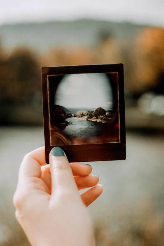 someone holding up an old picture in their hand