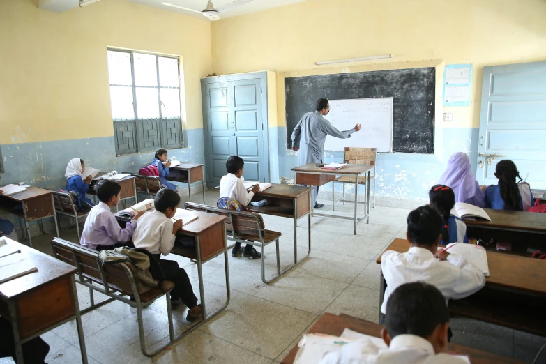 students at their desks in an empty classroom