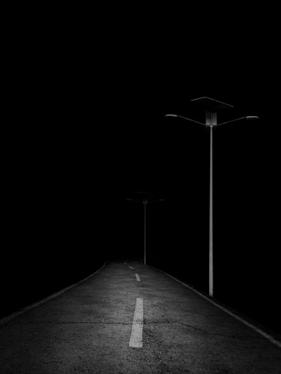 two light poles on the side of the road at night