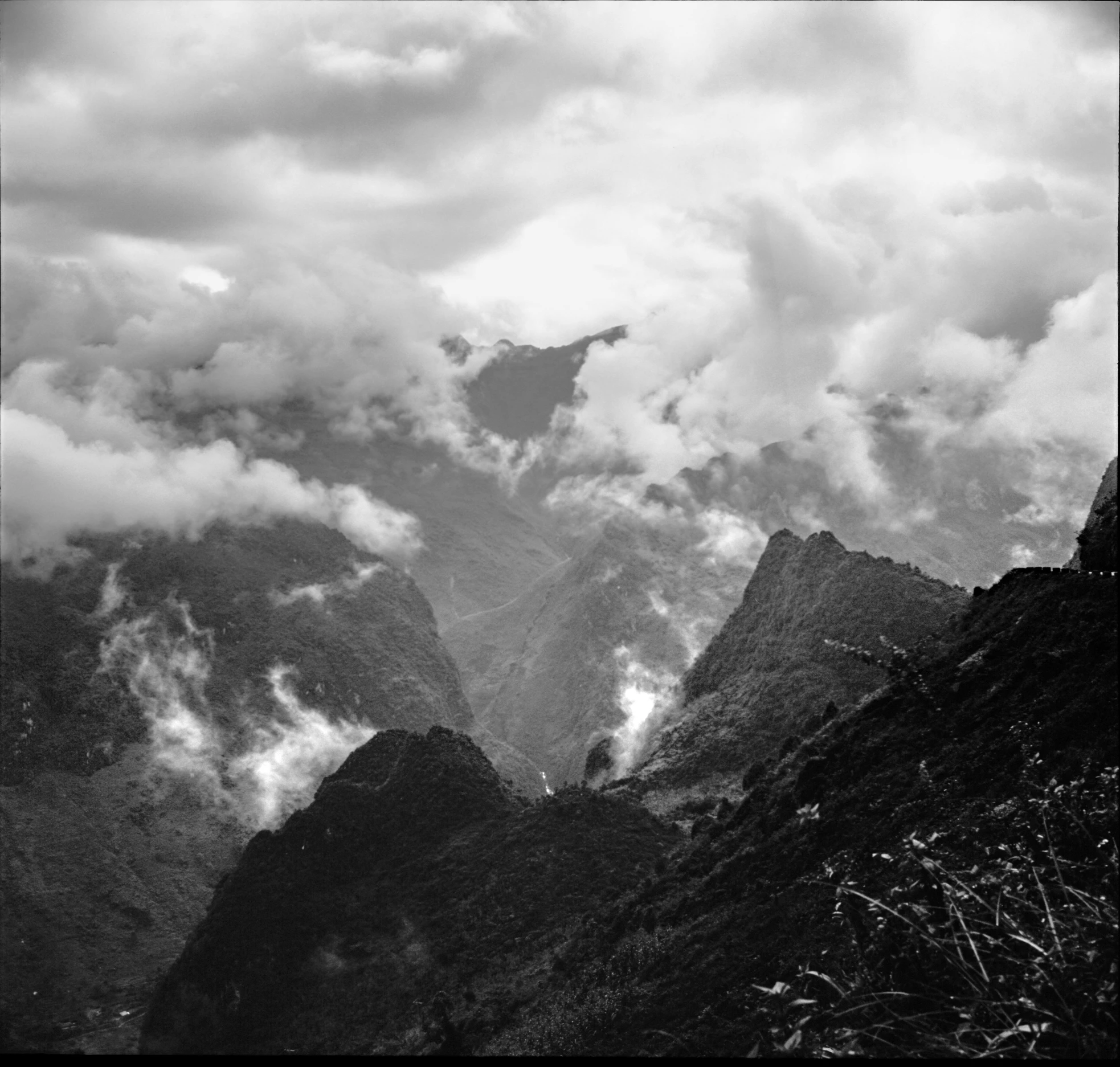 the mountains are covered in white clouds and light gray