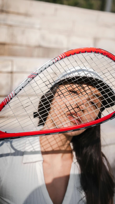 the woman is holding her racket over her face