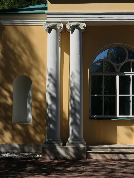 the white pillars are against a tan building