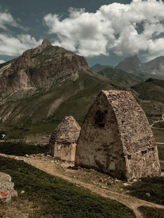 a small brick building in the middle of some mountains