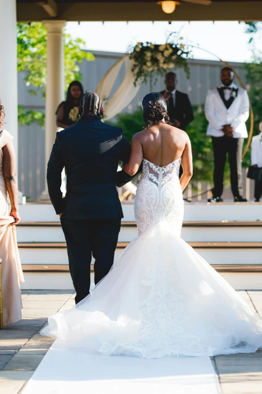 bride and groom walking to wedding ceremony in front of grooms