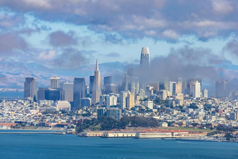 a cityscape and water with fog on the skyline