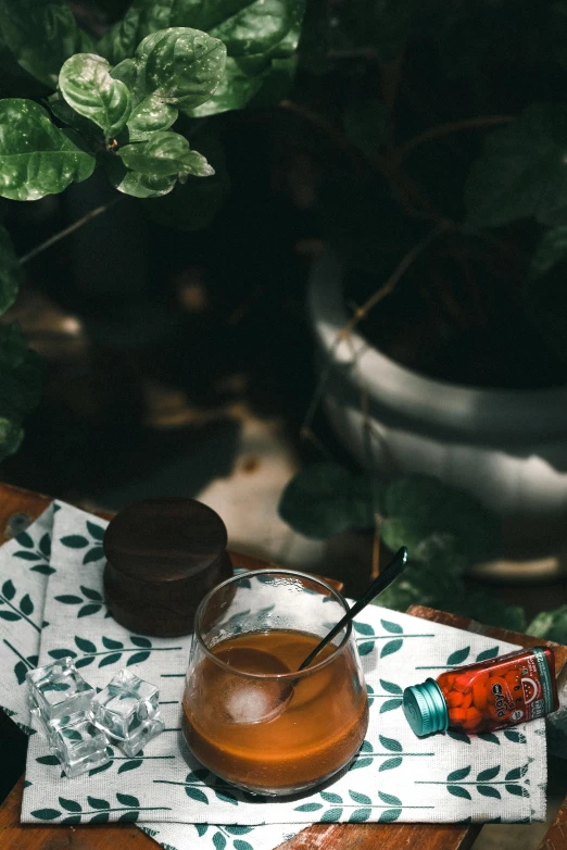 an alcoholic drink in a glass with a wooden lid and silver spoon