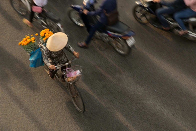 a person rides a bicycle with a large basket and flower arrangement