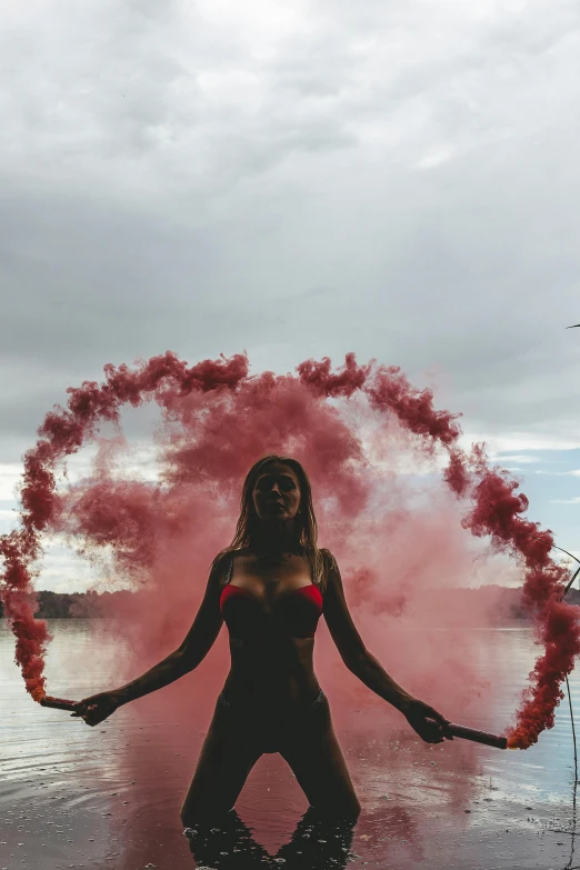 a woman standing in water near pink powder