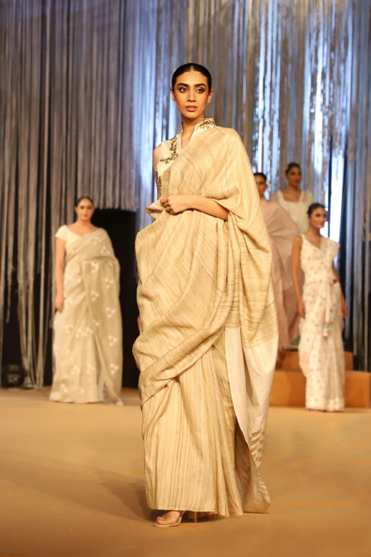 an indian woman in a dress on a runway