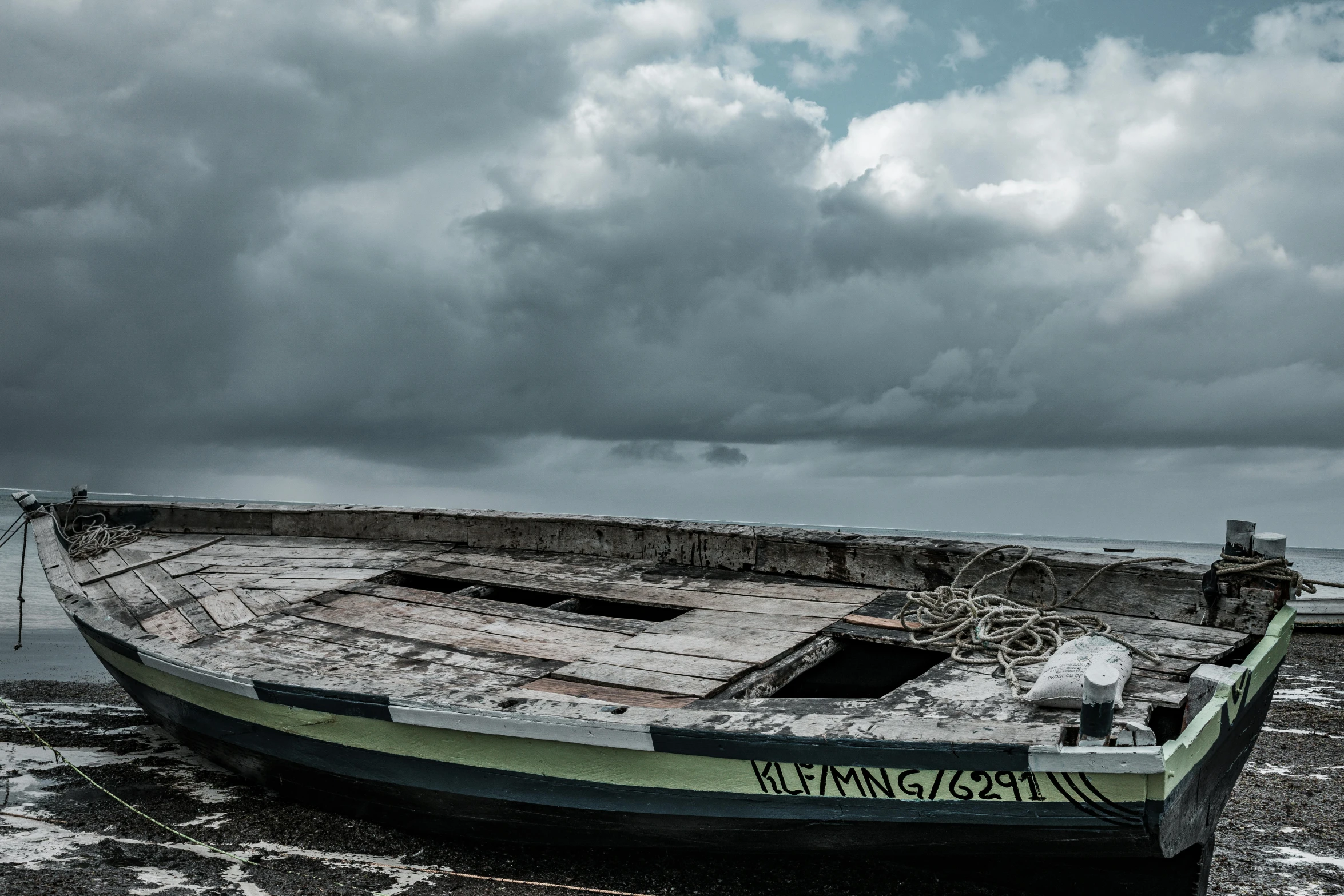 the abandoned boat is on the shore by itself