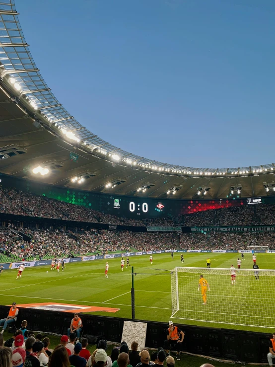 a crowd watches as people play soccer in a stadium