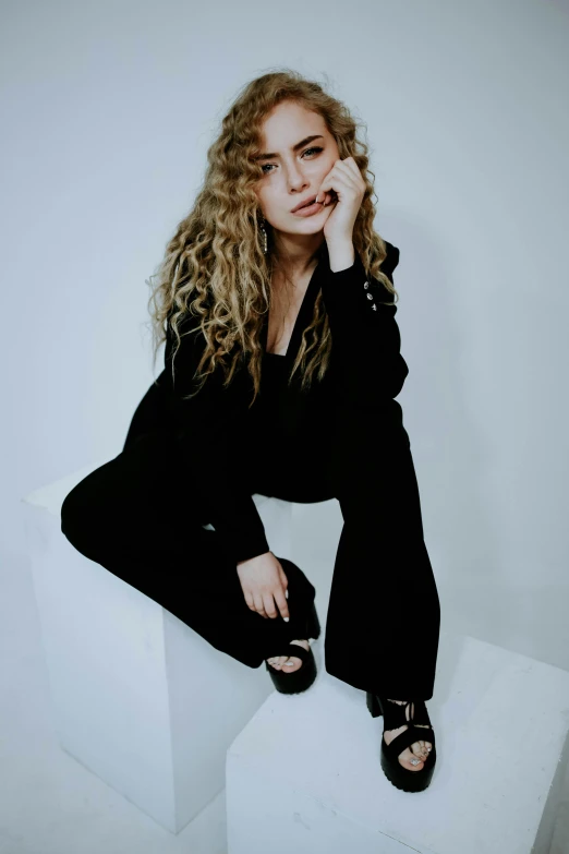 a woman sitting on a box wearing black clothes