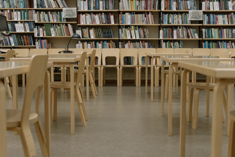 many wooden chairs are set in front of the shelves of books