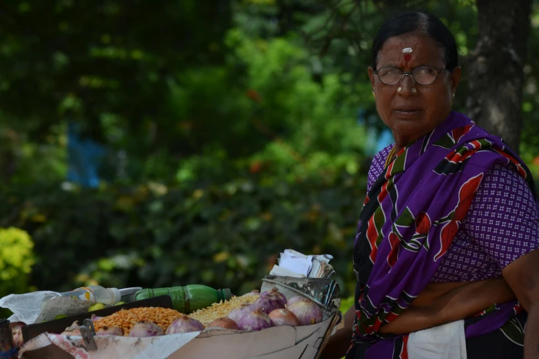 an elderly woman is standing next to baskets full of food