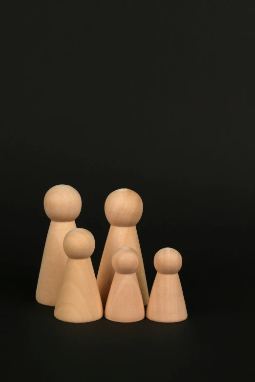 a close up of three wooden peg dolls