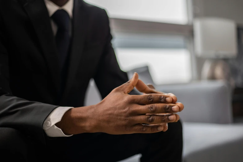 a person sitting down while wearing a suit