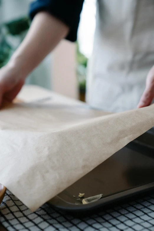 someone wrapping paper on top of a pizza pan