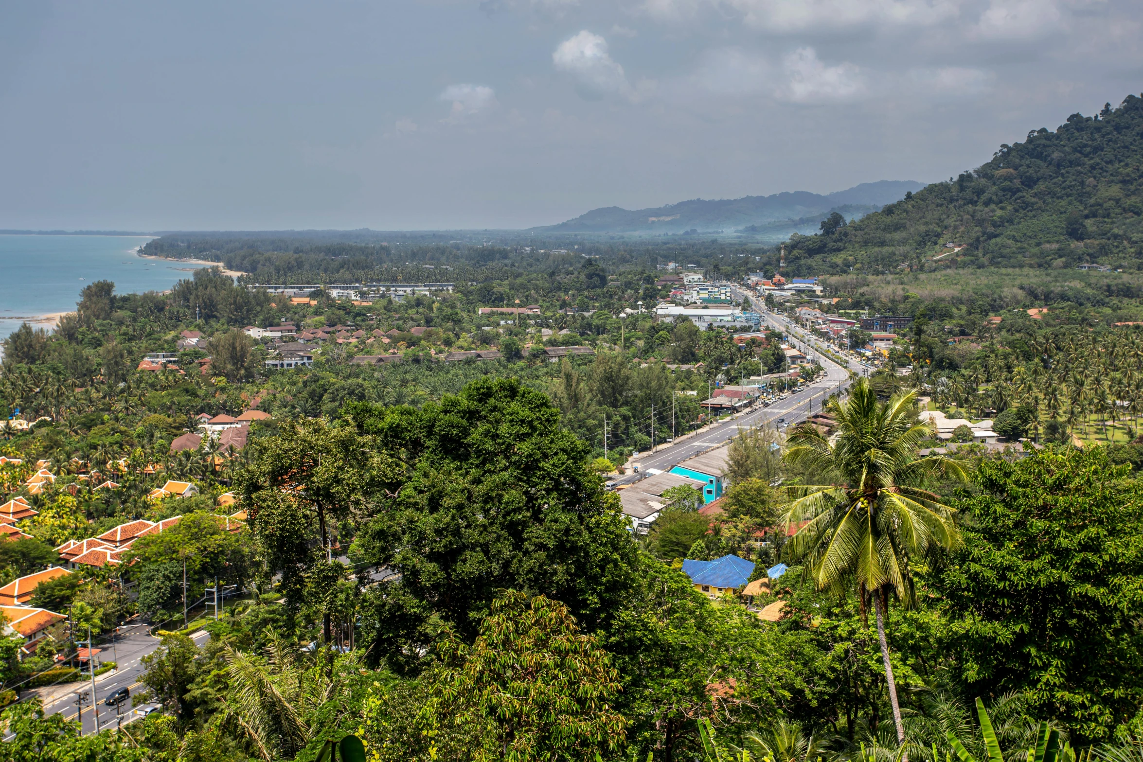 a town near the beach with mountains in the background