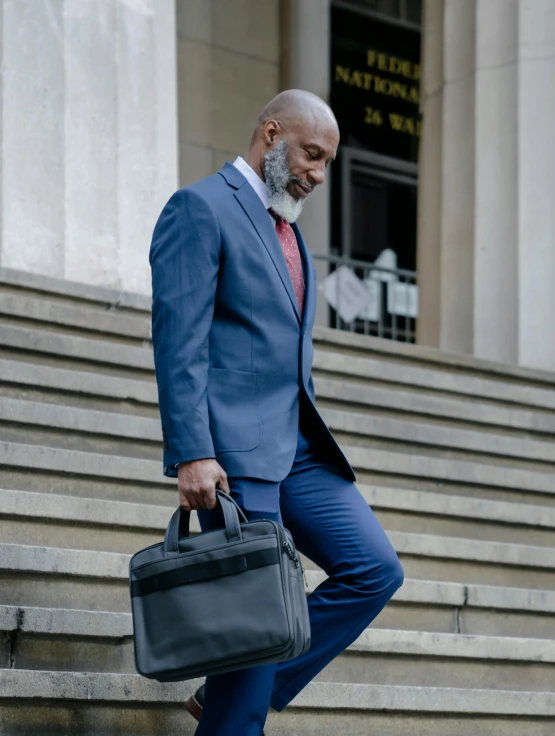 a man in a blue suit is carrying a briefcase