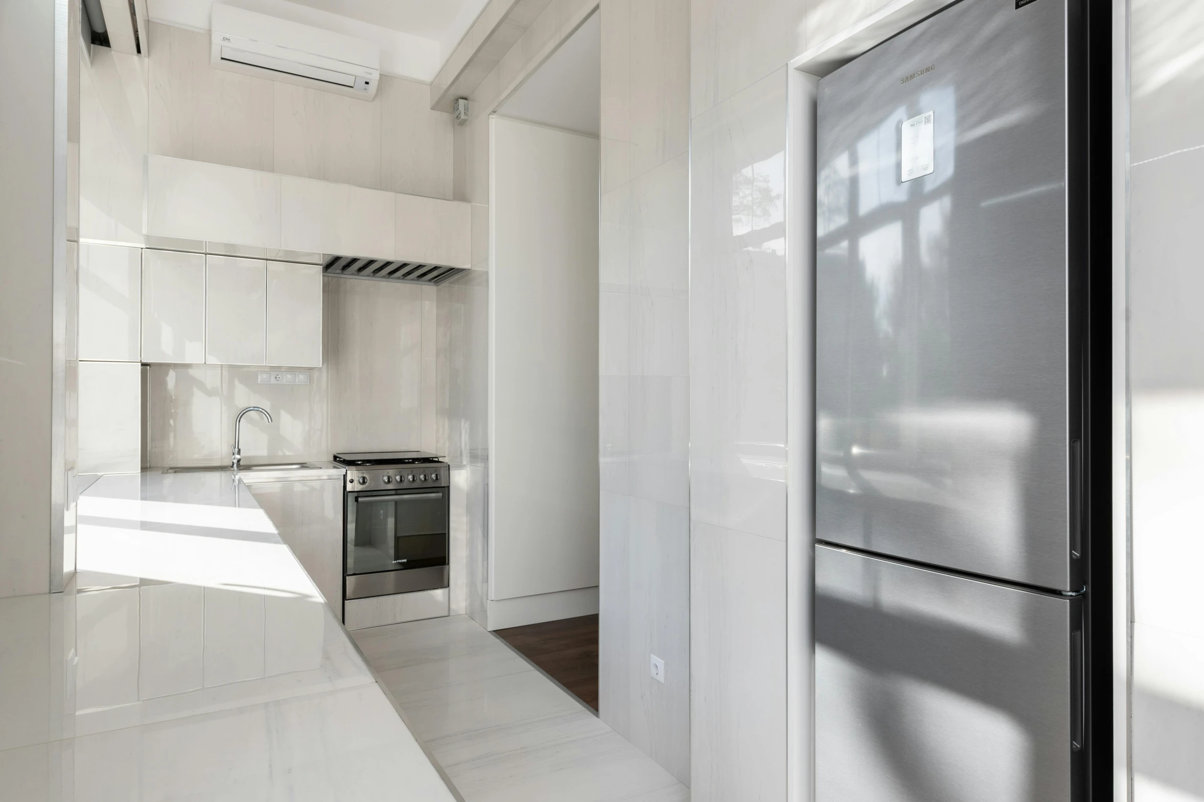 an empty white kitchen with an icebox in the wall