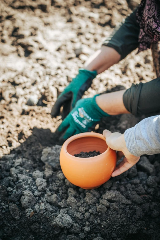 someone holding the end of a small, dirty orange cup