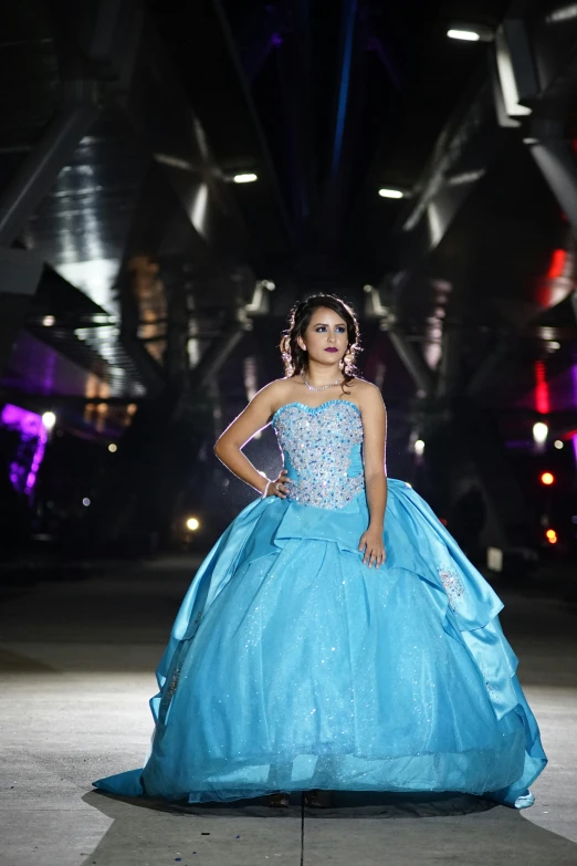 a young woman is posing in a blue dress