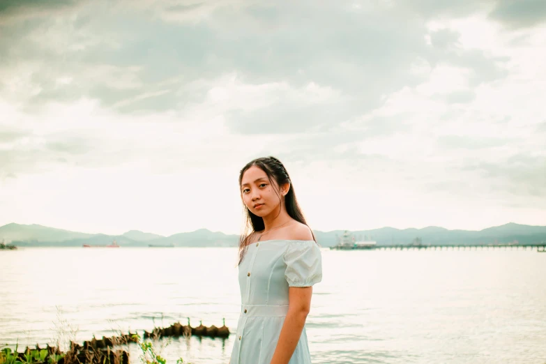 a woman standing in front of a body of water