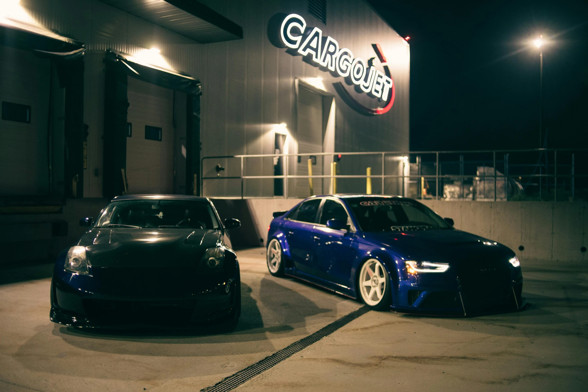 two cars sitting in a parking lot outside a store