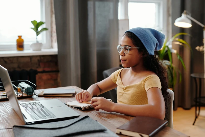 a woman wearing glasses looking at a laptop screen