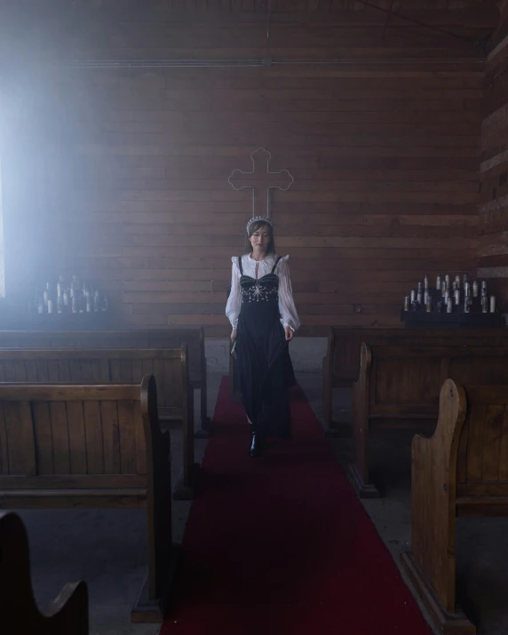 the woman is walking along the aisle in the church