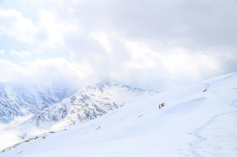 two people walking up the side of a snowy mountain