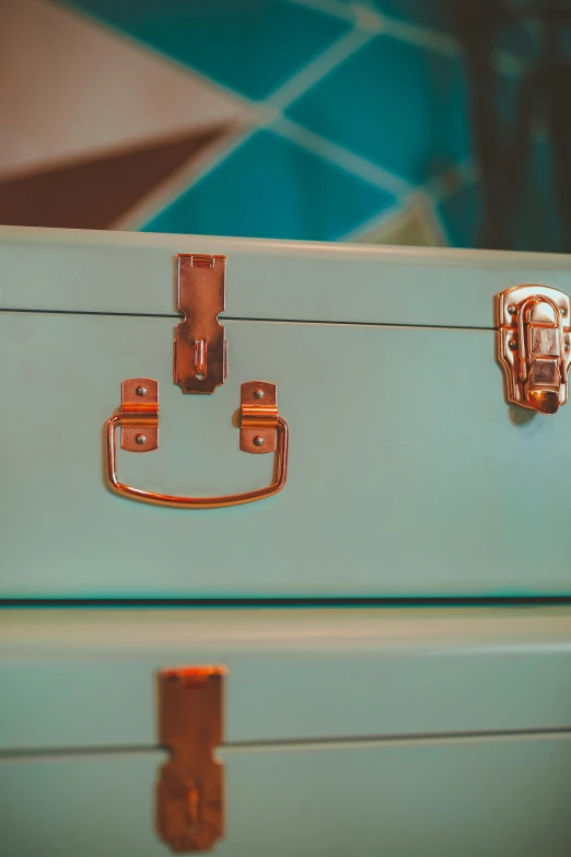 the small blue suitcase has four gold handles