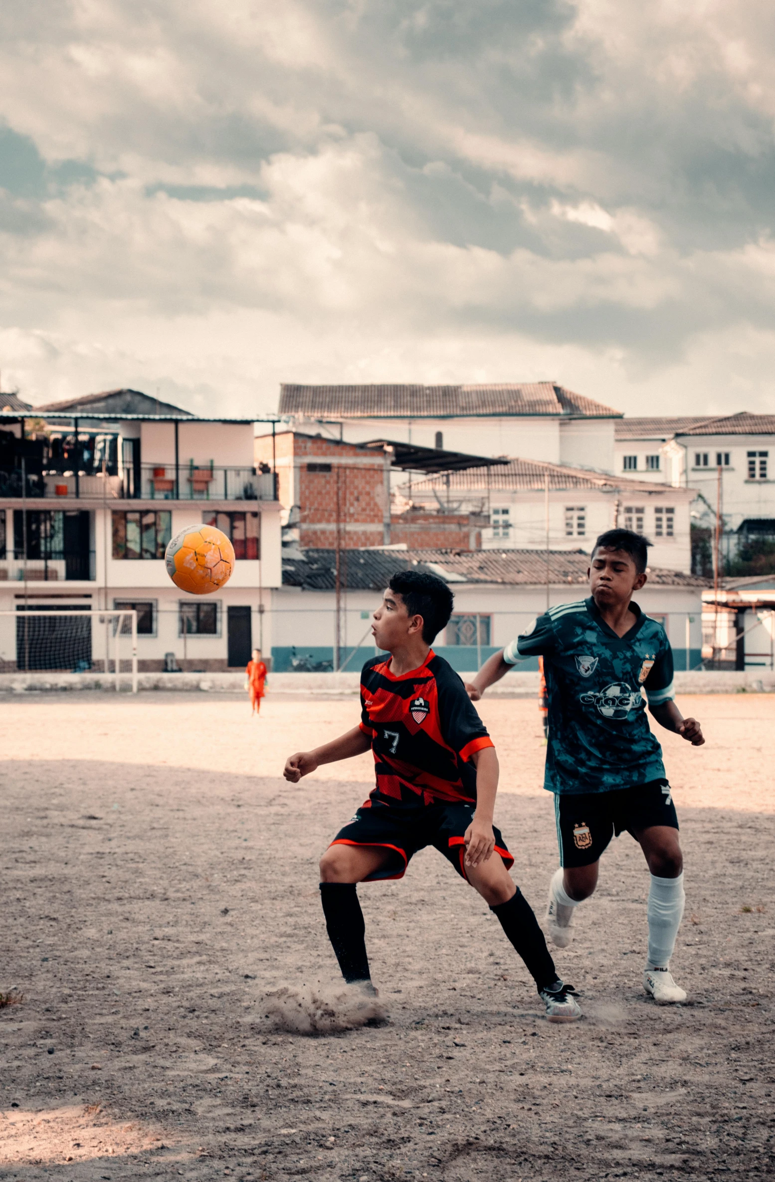 two soccer players in the middle of the court, chasing the ball