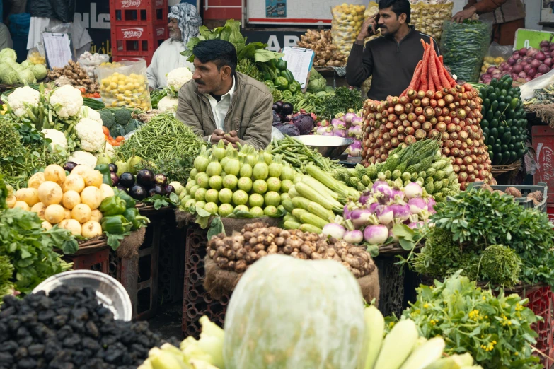 a man working in a vegetable market with lots of produce