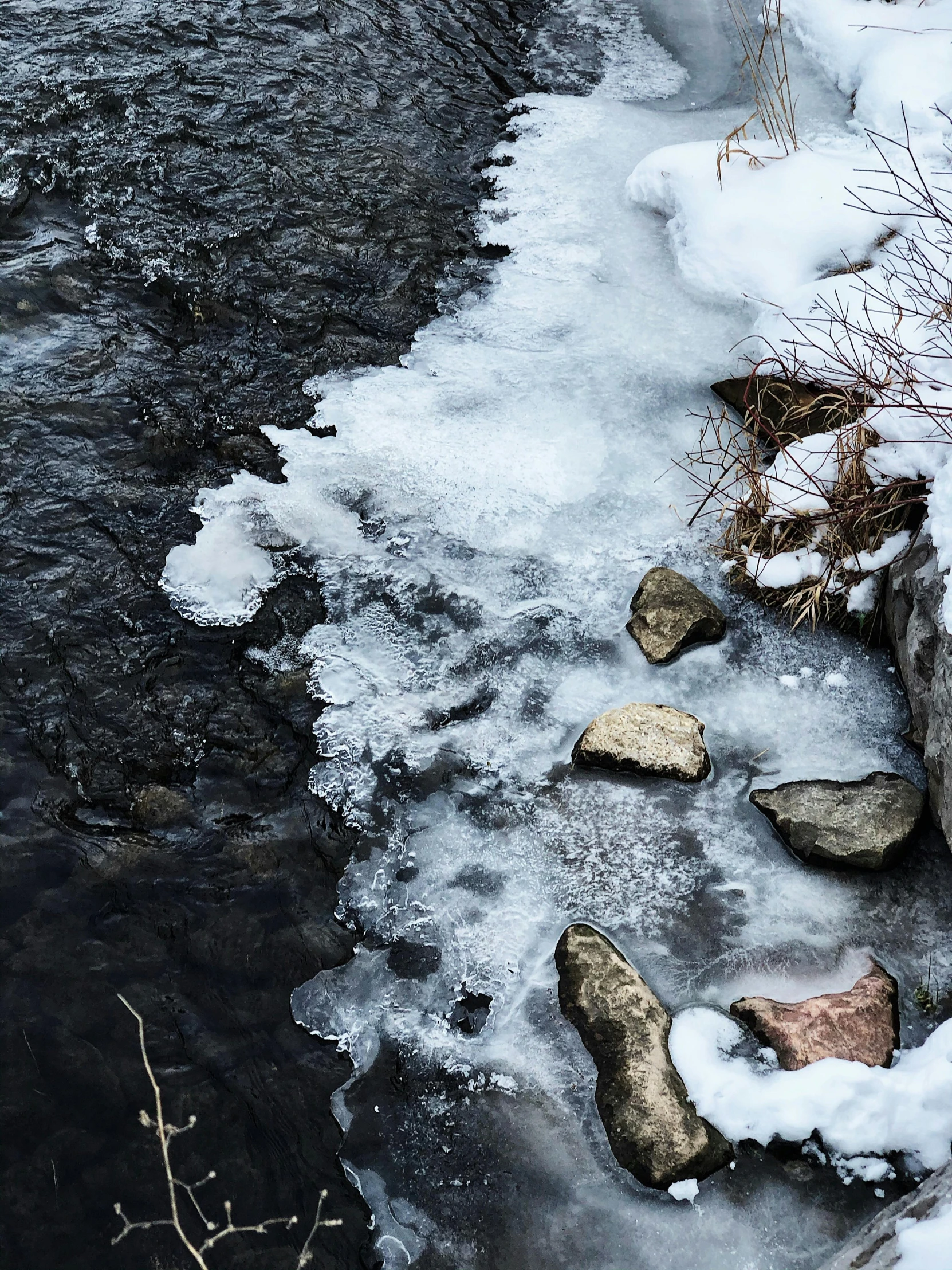 water that is flowing from a lake next to some ice