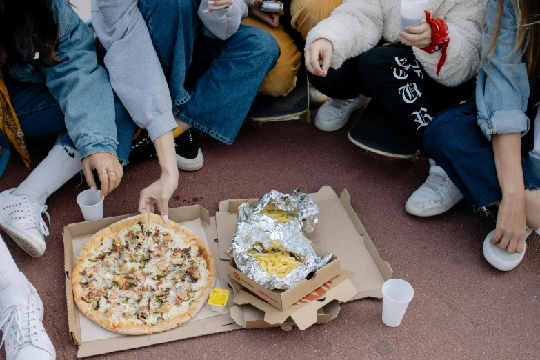 many people eating pizza and drinking soda