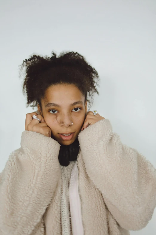 a young woman in a sweater is looking at the camera