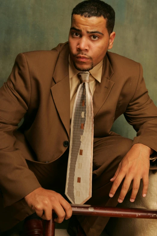 a man with a suit and tie sitting on a bench