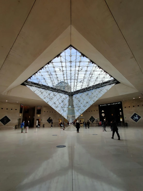 a big room with some people standing and sitting