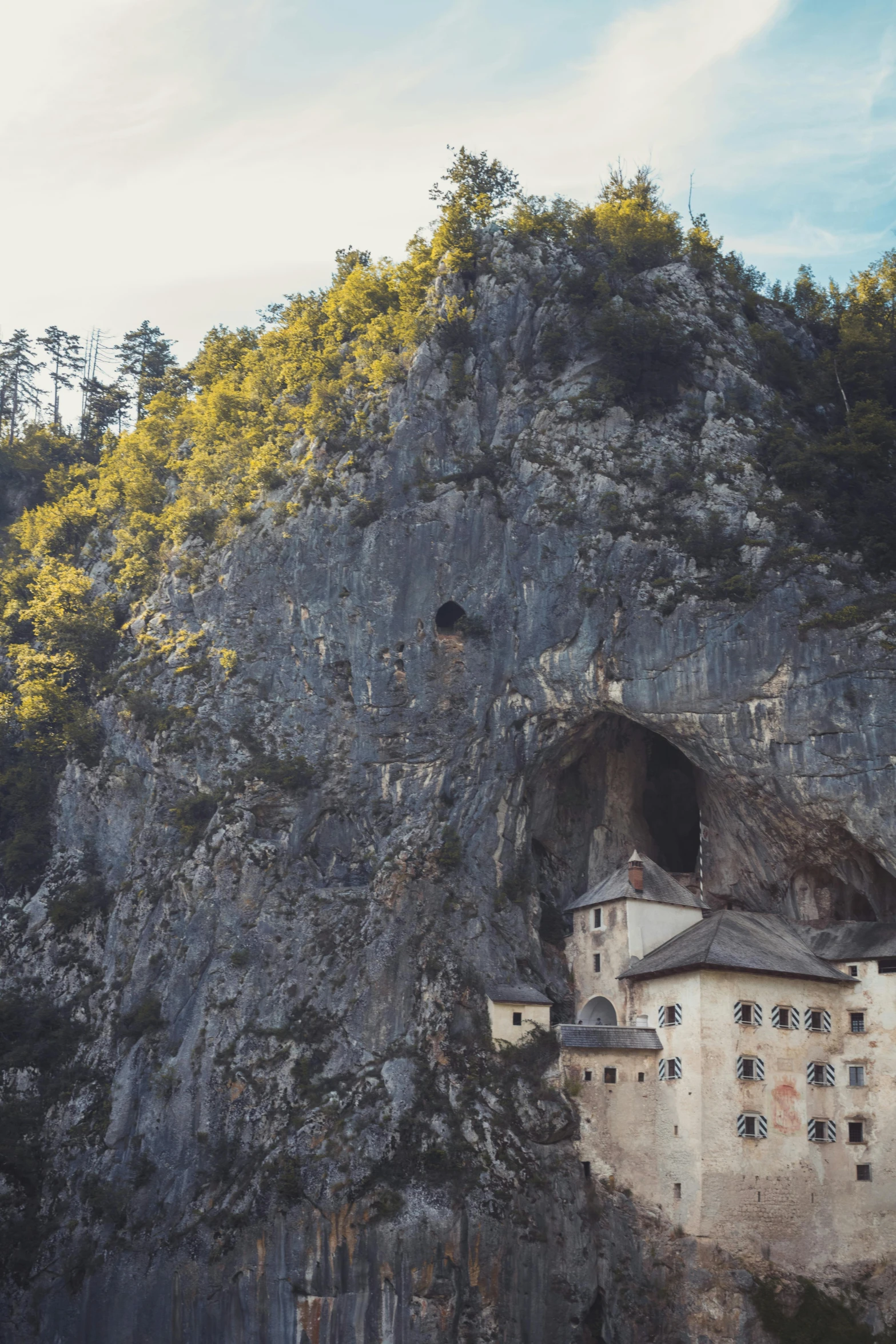 a cliff on top of a mountain with a castle inside of it