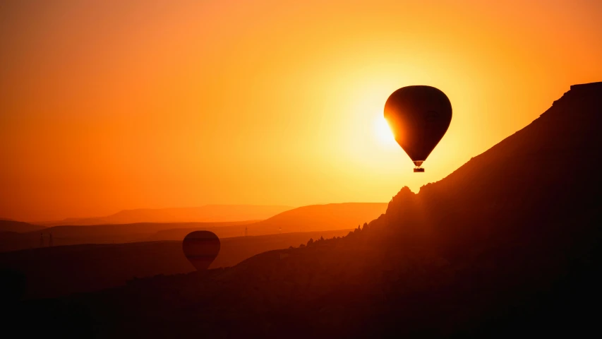 two  air balloons flying across a sky