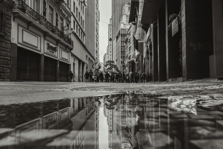 several people walking along a city sidewalk next to tall buildings